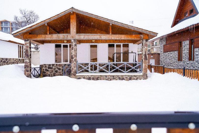 a house with snow on the ground in front of it at Kottage ji in Bakuriani