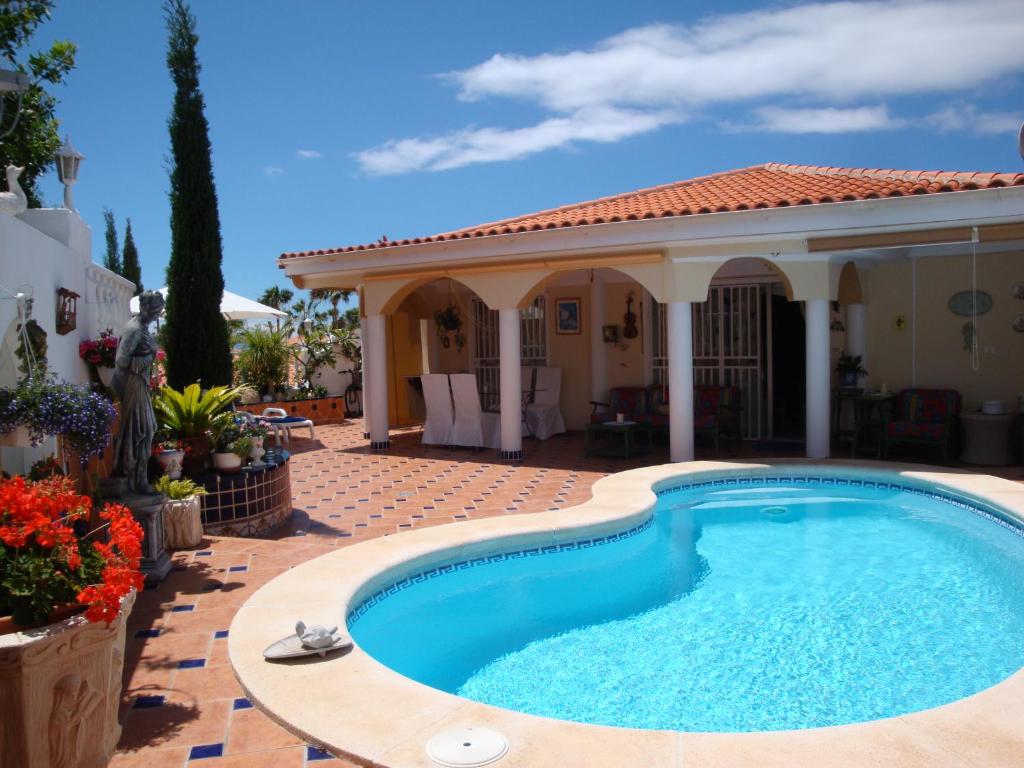 a swimming pool in front of a house at Villa Violetta in Callao Salvaje