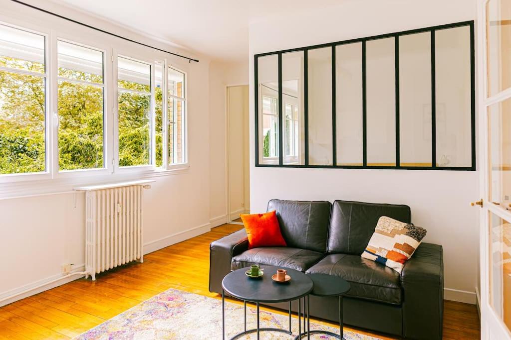 un salon avec un canapé et une table dans l'établissement Studio Eiffel Tower Necker, à Paris