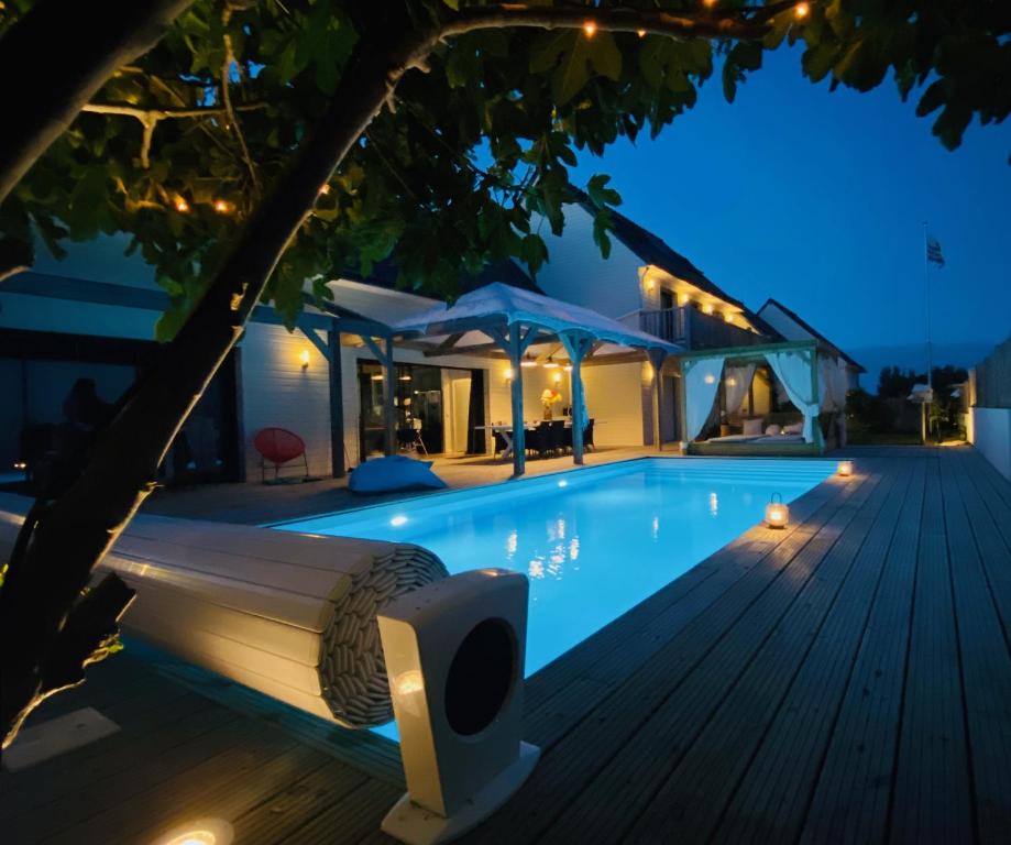 une piscine avec un banc à côté d'une maison dans l'établissement La Villa Majo, à Quiberon