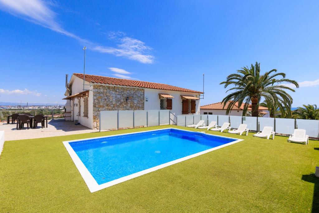 a villa with a swimming pool in front of a house at PANORAMIC VILLA x in Salou
