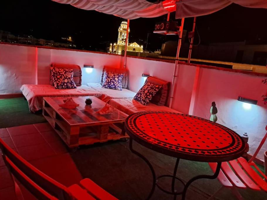 a red room with a table and a couch at Pequeña Gran casa in Almuñécar