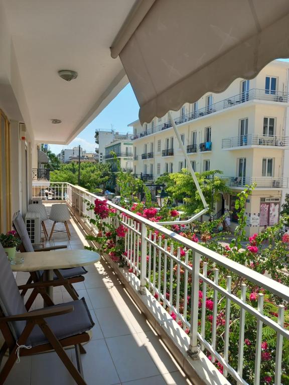 a balcony with a table and chairs and flowers at Hra in Loutraki