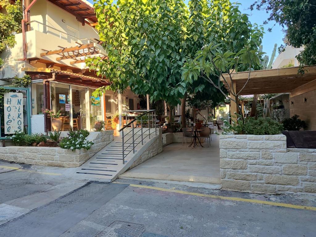ein Gebäude mit Treppen und einem Baum auf der Straße in der Unterkunft Nikos Hotel in Matala