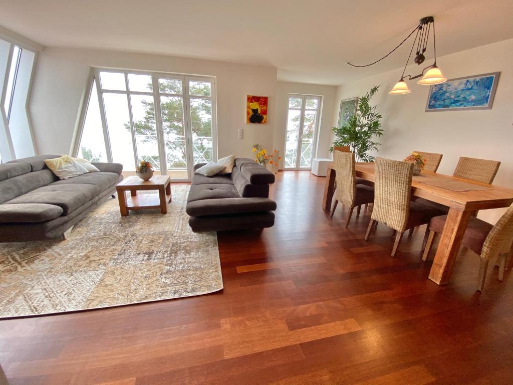 a living room with a couch and a table and chairs at Mal-Düne in Binz