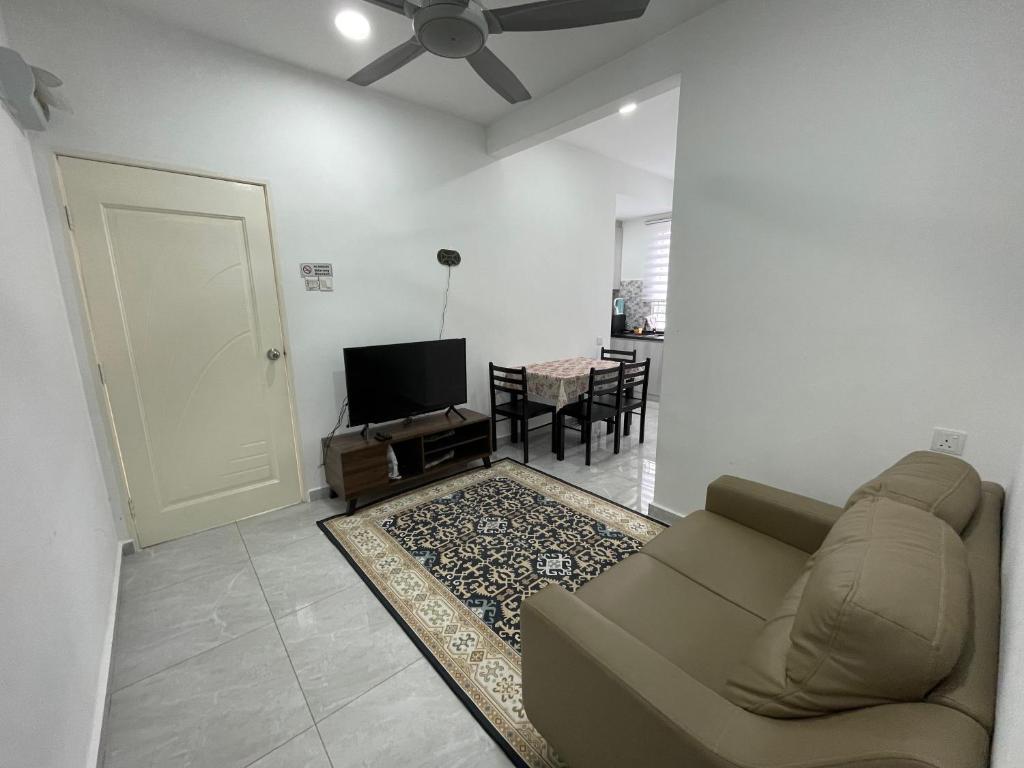 a living room with a couch and a flat screen tv at Penang Studio Homestay at Kelawai Rd, Georgetown by SK Vacation Homes in George Town