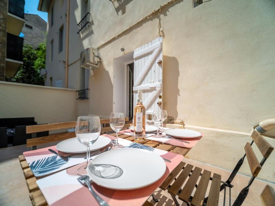 - une table avec des verres à vin et une bouteille dans l'établissement Appartement High Standing - Jardin & Climatisation - Les Frères de la Loc', à Marseille