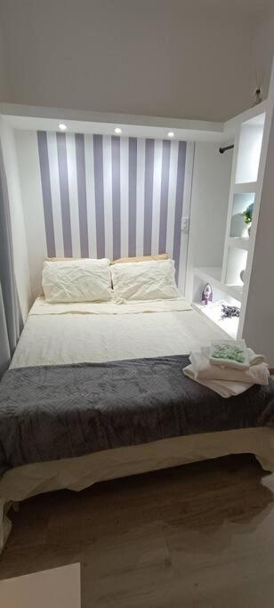 a bed with a striped headboard in a bedroom at Apartamento Studio no centro de São Lourenço in São Lourenço