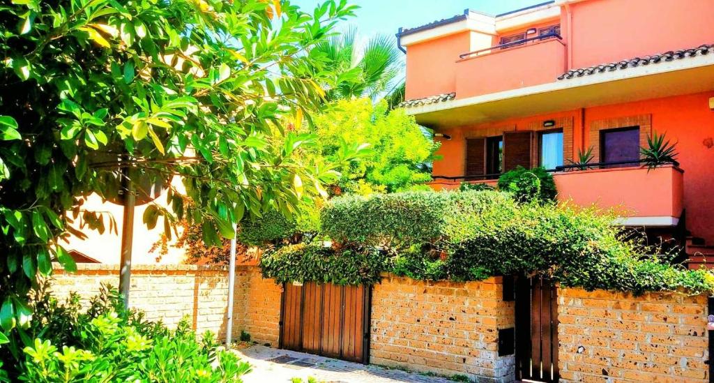 a brick building with a fence and trees in front of it at Villa Corina - Appartamento Pescara vicino al mare in Pescara