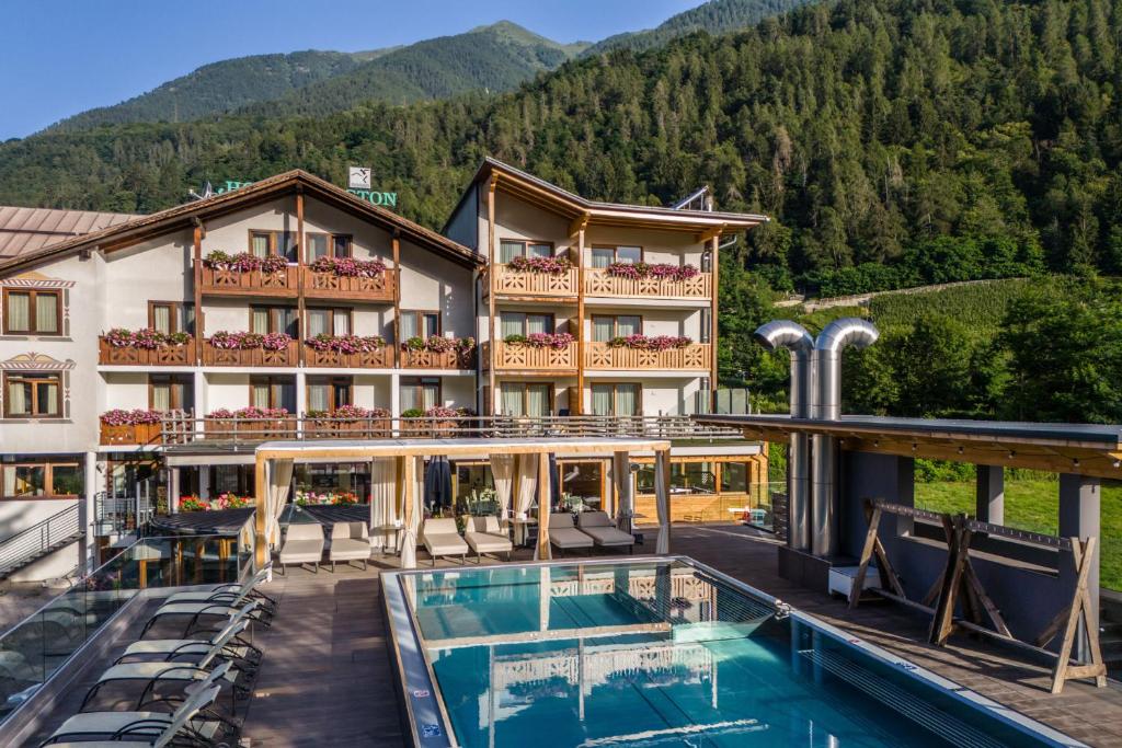 a hotel with a pool and mountains in the background at Hotel Ariston Garden & Spa in Monclassico