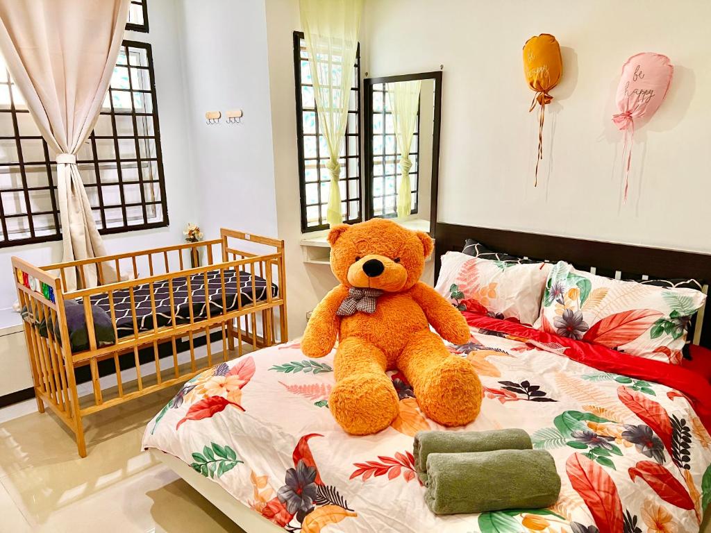un orsacchiotto seduto su un letto in una camera da letto di Teddy House with Kids Corner at Bukit Indah Near Legoland and EcoBotanic a Johor Bahru