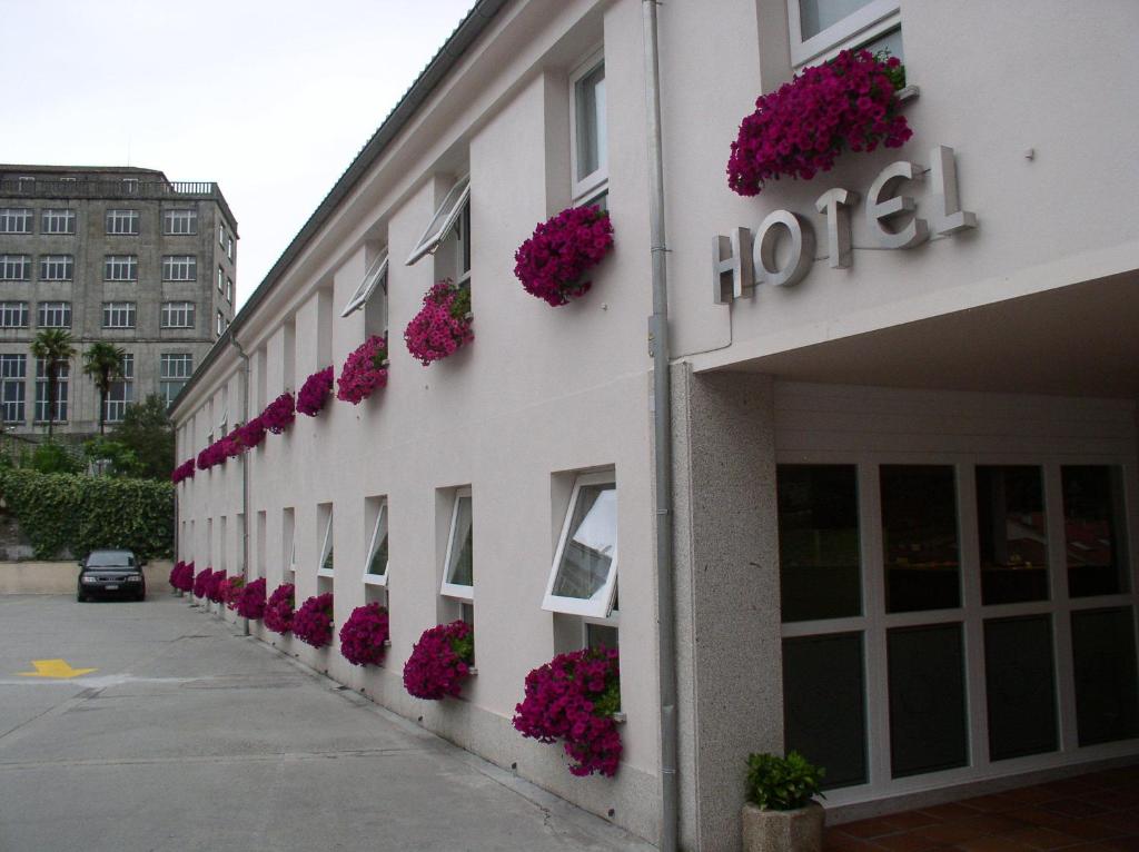 a hotel with pink flowers on the side of a building at Hotel Parking Miradoiro de Belvís in Santiago de Compostela