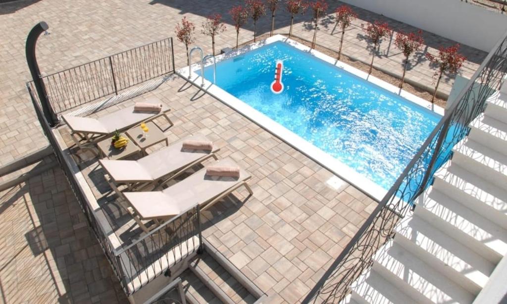 een uitzicht over een zwembad met een tafel en stoelen bij Villa Nonna in Vodice