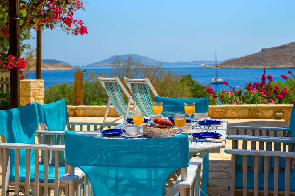 a table with chairs and a table with food and drinks at Villa Ftenagia in Halki