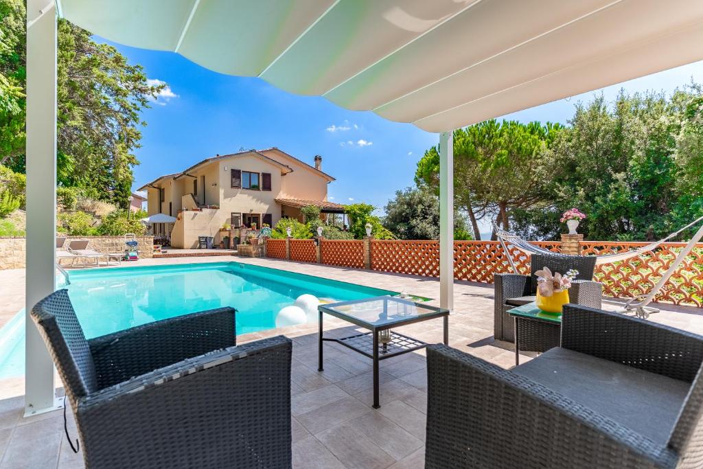 ヴォルテッラにあるPool, 5 Mins to Volterra Center, 4 Sleepsの家の隣にテーブルと椅子付きのスイミングプール