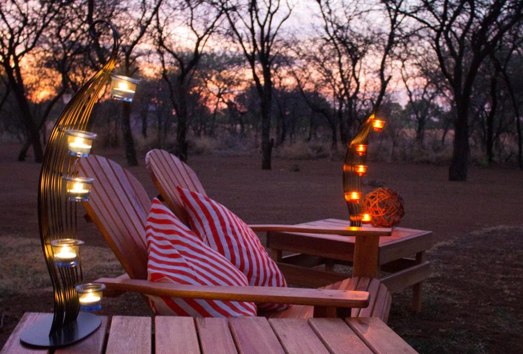 two chairs sitting on a picnic table with lights at Foreva Wild in Klipdrift