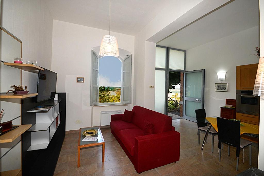 a living room with a red couch and a table at Casa Lulù in Montepulciano