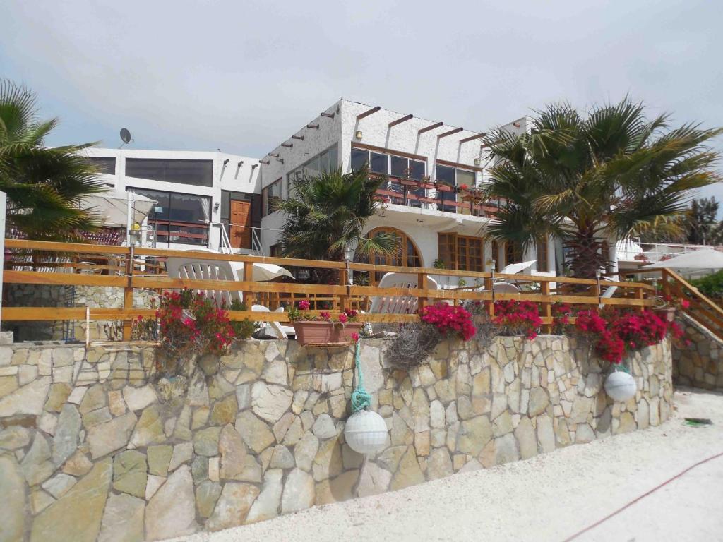 un edificio con flores en una pared de piedra en Hotel & Cabañas El Mirador Caldera, en Caldera