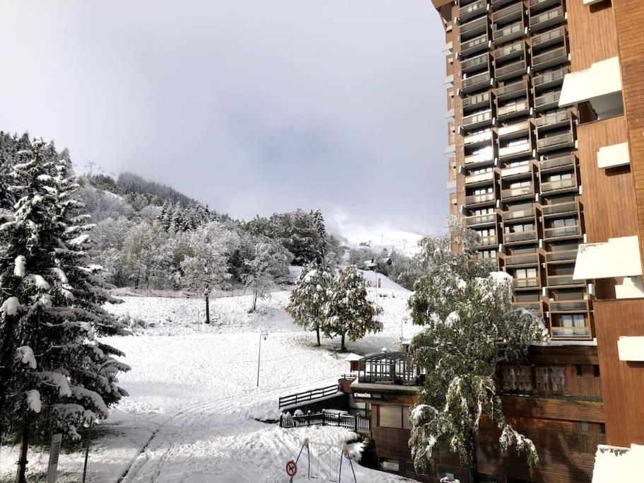a balcony of a building with snow on the ground at Appartement Station Le Corbier in Villarembert