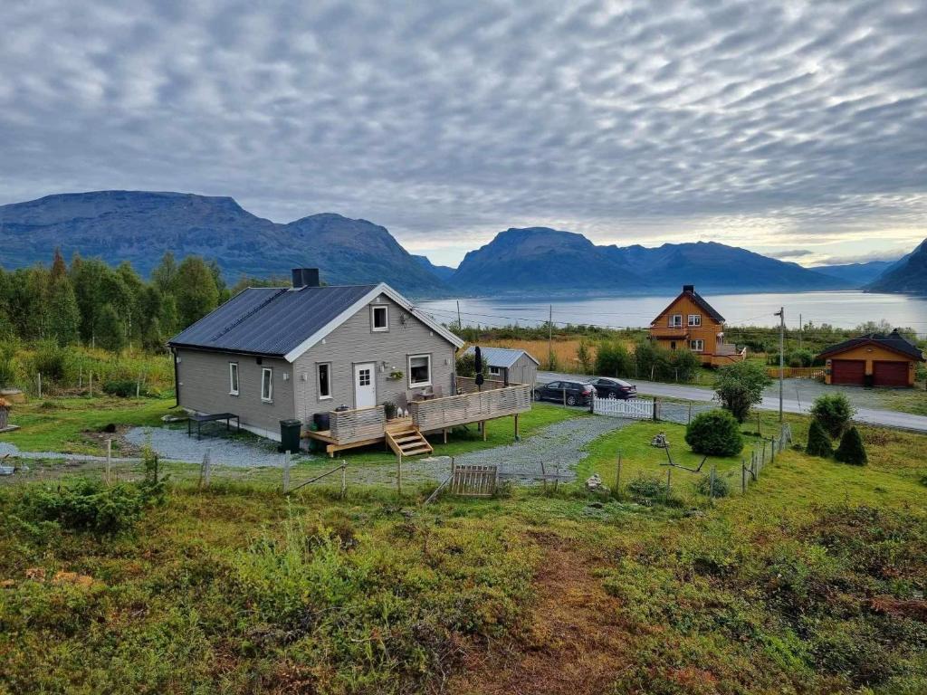 a house in a field with mountains in the background at Hytte i Skinnelv, Lyngen in Skinnelv