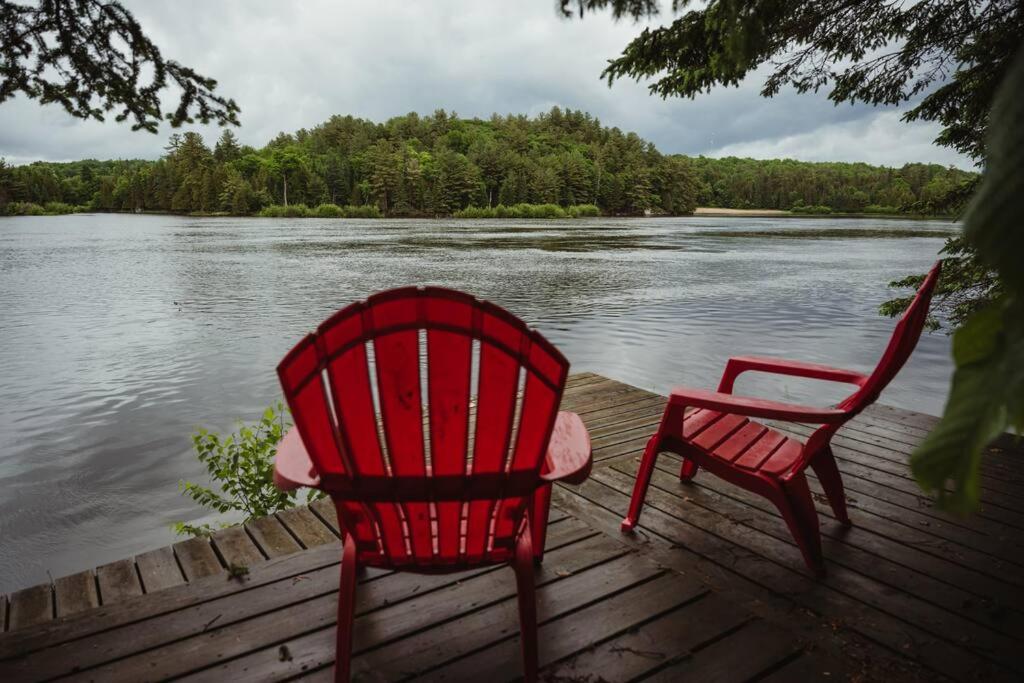 two red chairs sitting on a dock next to a lake at Waterfront lux loft 2 bedroom perfect for couples in Bryson