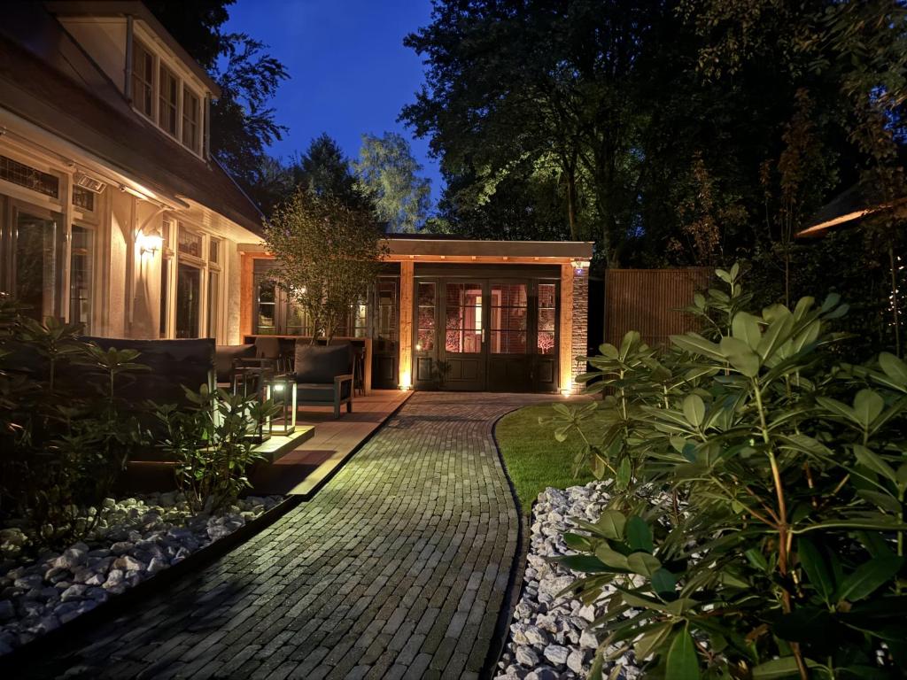 een achtertuin van een huis met een bakstenen patio bij Berg en Bos Suite in Apeldoorn