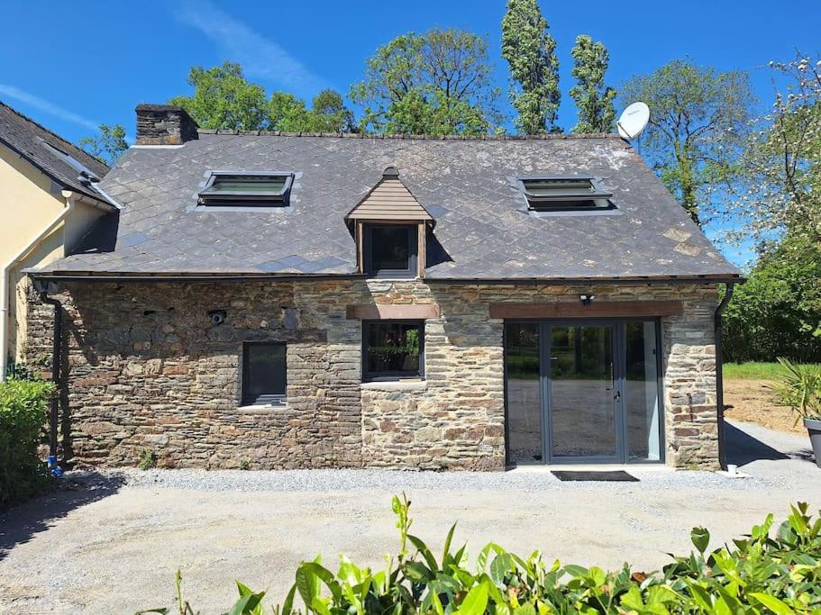 a stone house with a large garage in front of it at maison de caractère la petite madeleine in Saint-Laurent