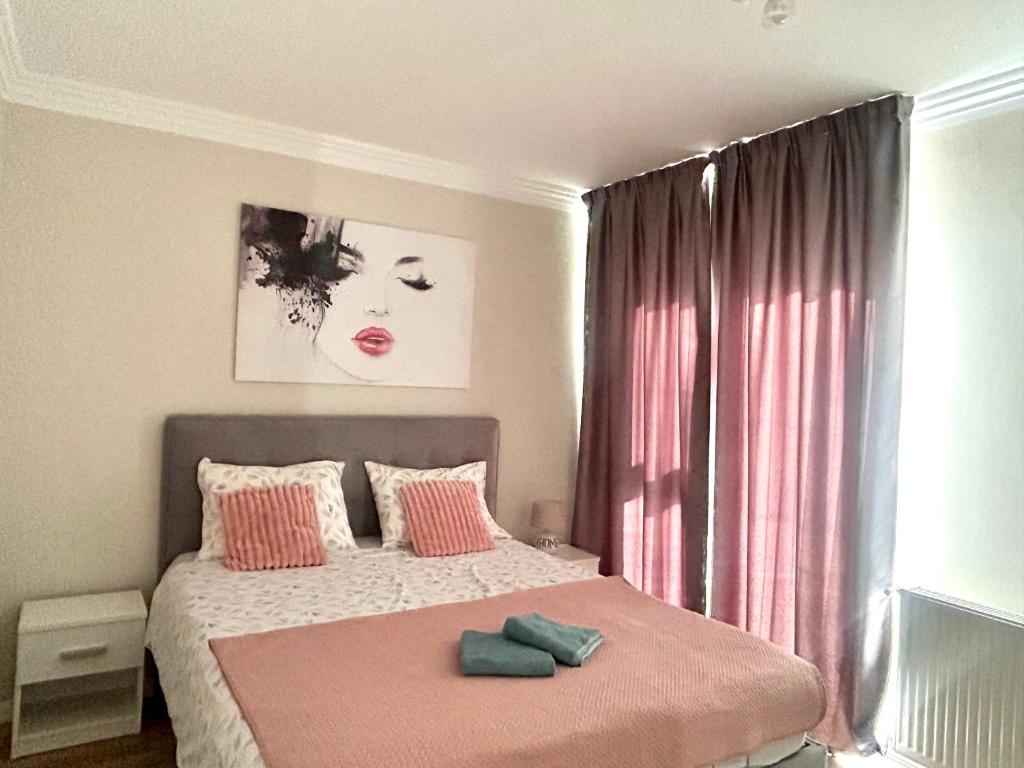 a bedroom with a bed with pink sheets and a window at Divany Apartaments Brasov - Coresi Mall in Braşov