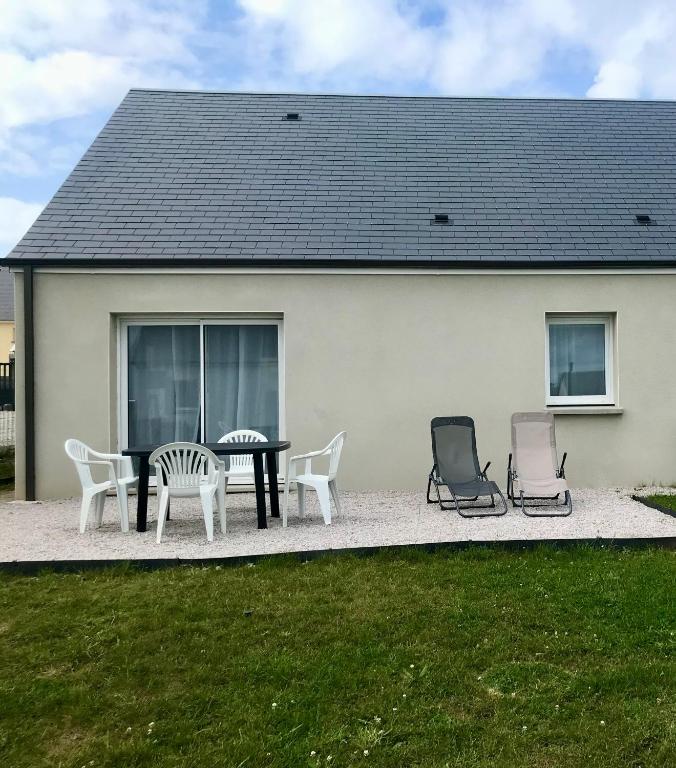 un patio avec des chaises et une table devant une maison dans l'établissement Maison 6-8 personnes 3 chambres, aux Pieux