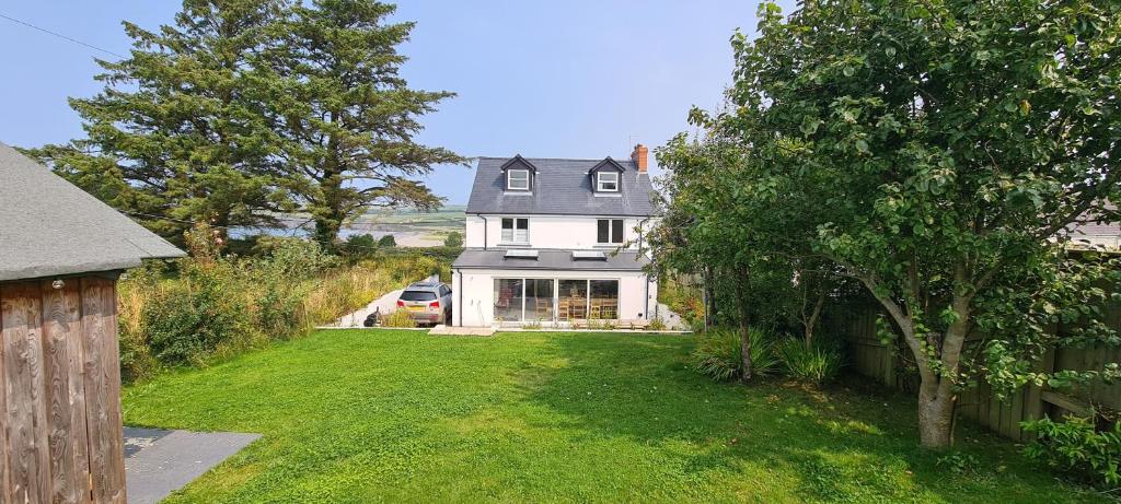 a white house with a car parked in the yard at Cippinstone in Newport Pembrokeshire
