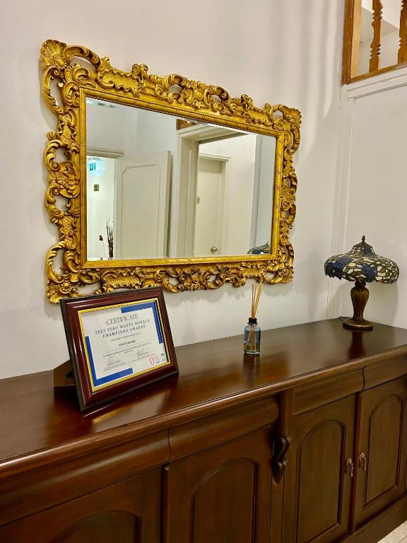 a mirror sitting on top of a wooden dresser at Two Flowers Hotel in Pedoulas