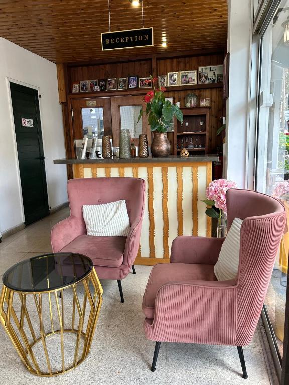 a living room with two chairs and a table at Two Flowers Hotel in Pedoulas