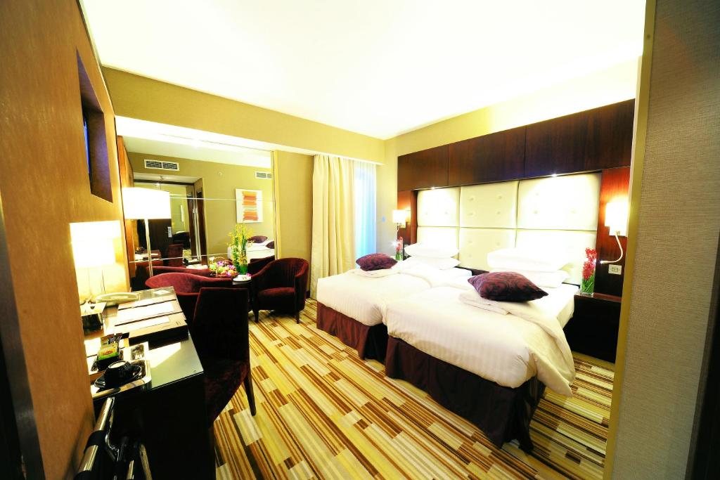 una camera d'albergo con un grande letto e una scrivania di Monaco Hotel a Dubai