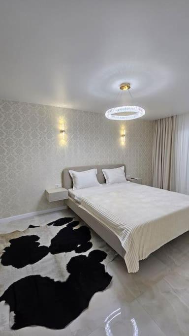 a bedroom with a large bed with a cow rug at Квартира в Бендерах VIP in Bender