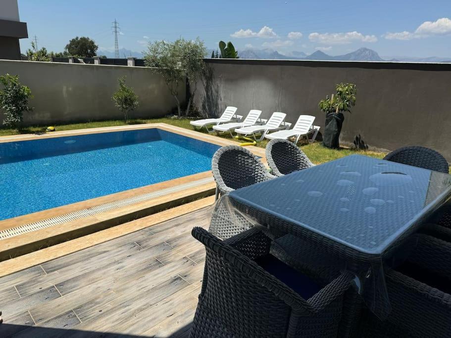 DosemealtiにあるMisafirlerin favorisi Villa nazのスイミングプールの横のテーブルと椅子