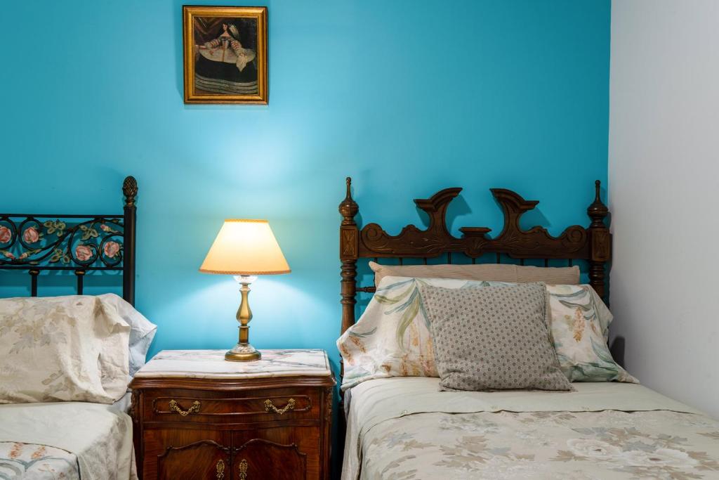 a blue bedroom with two beds and a lamp at Mirador 5 del Mercado Central - habitacion con baño privado en el centro de la Ciudad Vella in Valencia