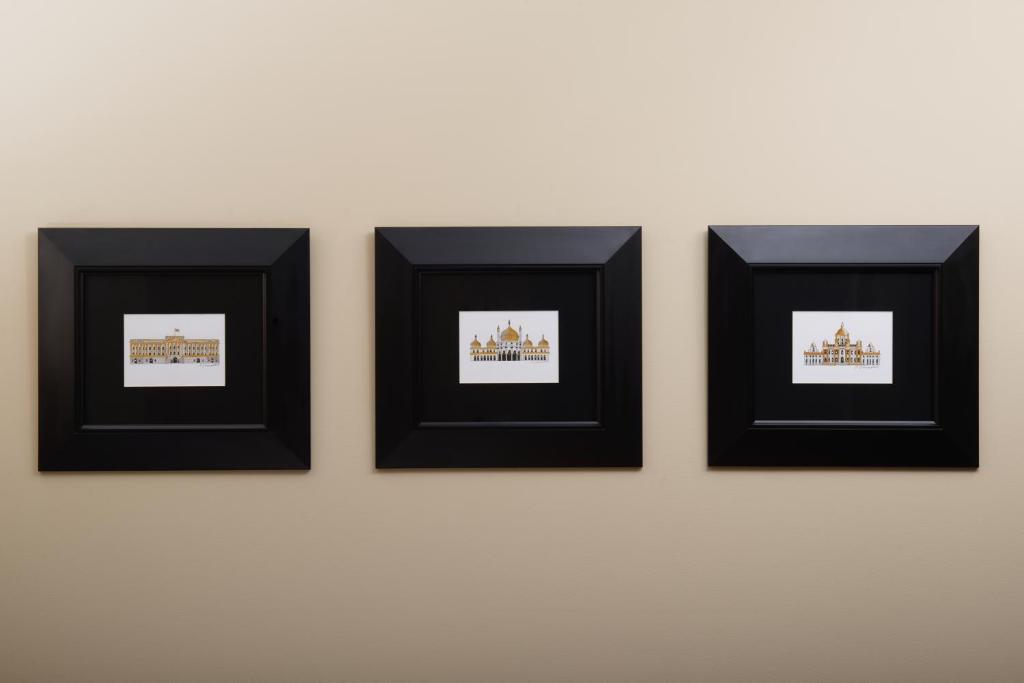 a group of framed pictures hanging on a wall at The Resident Victoria in London