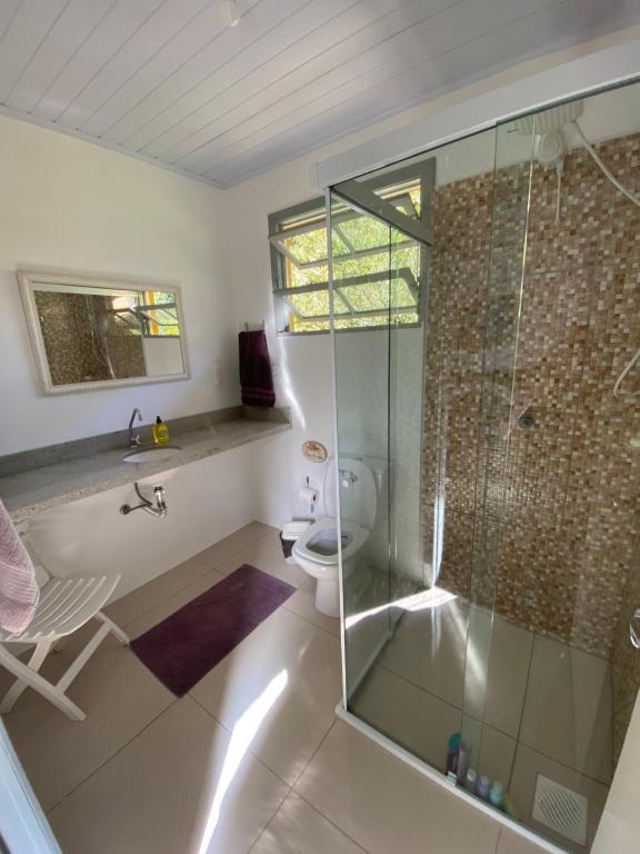 a bathroom with a shower and a sink and a toilet at Recanto da Cancela in Penha