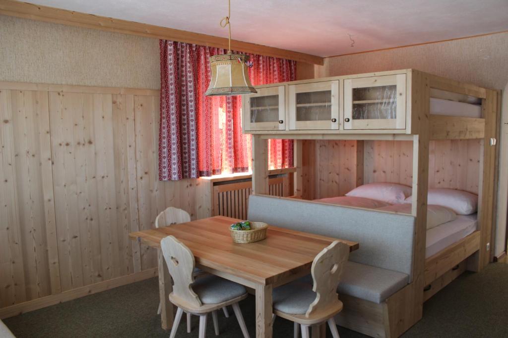 a room with a table and a bunk bed at Berghaus-Olymp Kronplatz in Brunico