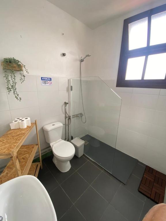 a bathroom with a toilet and a shower and a sink at Rota Ria Alojamento Local in Aveiro