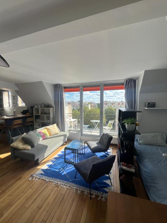 un salon avec un canapé et une table dans l'établissement Studio Artiste Paris, à Paris