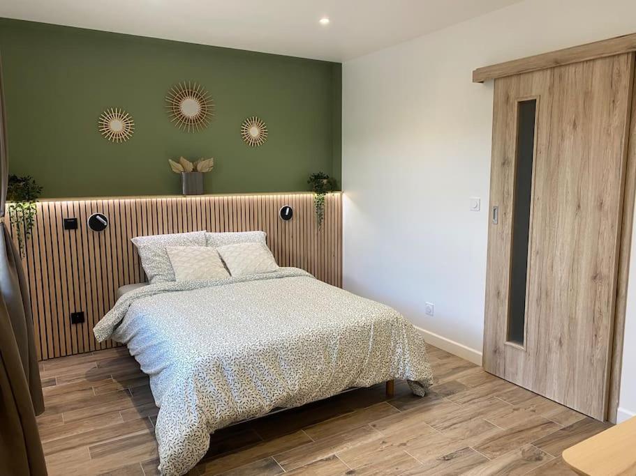 a bedroom with a bed and a green wall at Gite 2 du grand Pavillon in Rocroi