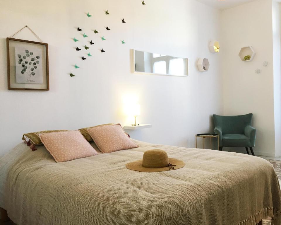 une chambre avec un lit avec un chapeau dessus dans l'établissement Magnifique Appartement avec cour extérieure privée, à Aix-en-Provence