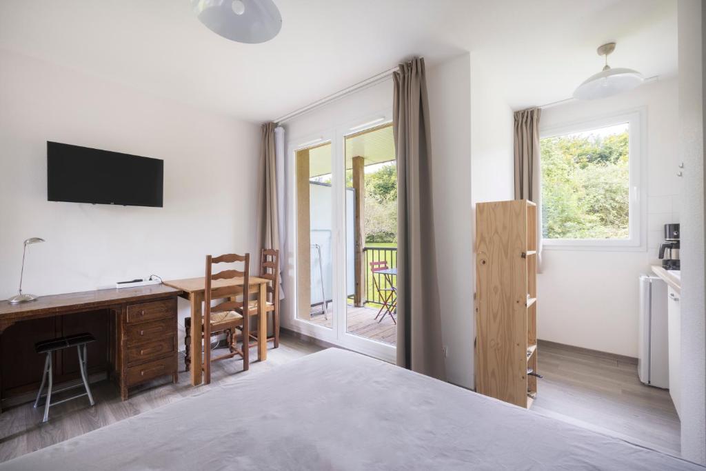une chambre avec un lit, un bureau et une fenêtre dans l'établissement Appartement normandie avec piscine et jardin, à Équemauville