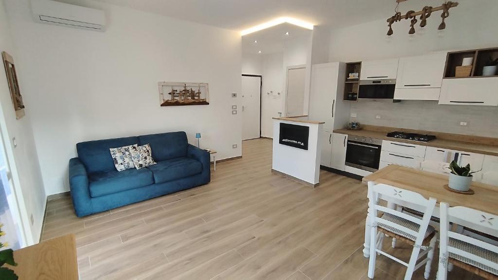 een woonkamer met een blauwe bank en een keuken bij Conca del Sole in Rapallo