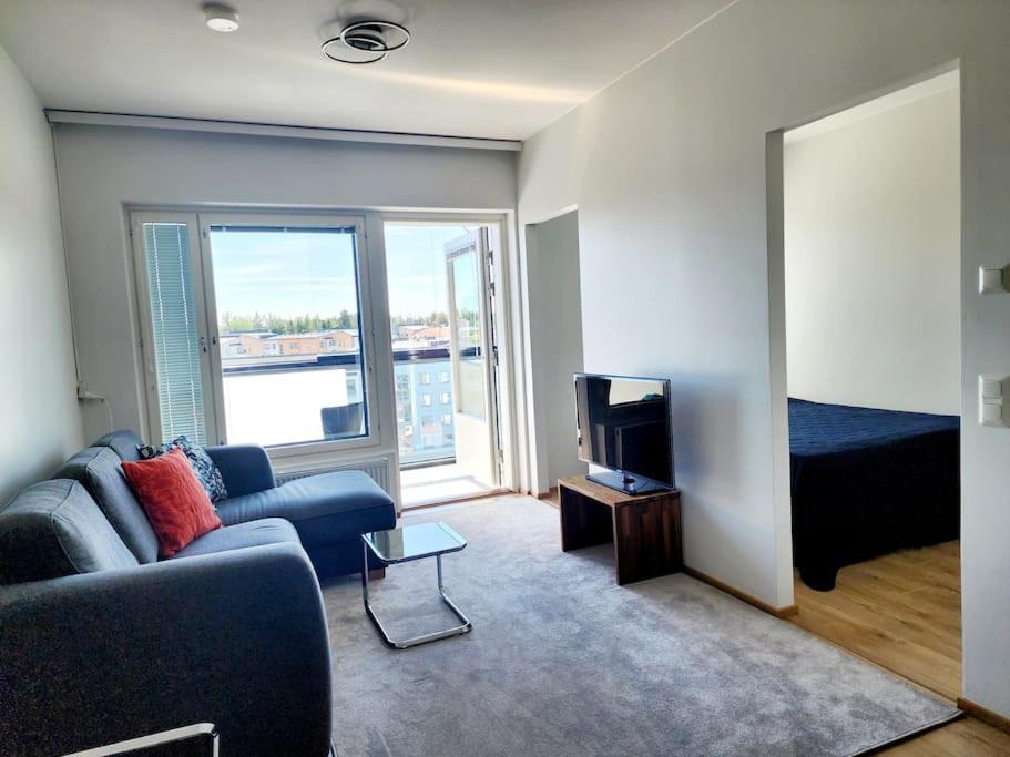 una sala de estar con un sofá y un televisor en Top floor, en Espoo