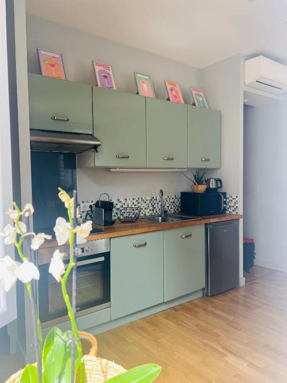 une cuisine avec des armoires blanches et un évier dans l'établissement Appartement avec balcon, centre Cannes, à Cannes