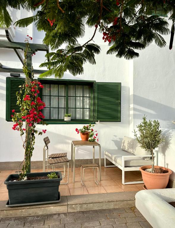 a patio with a bench and a table and some plants at Casa Pepe Las Candelarias in Agaete