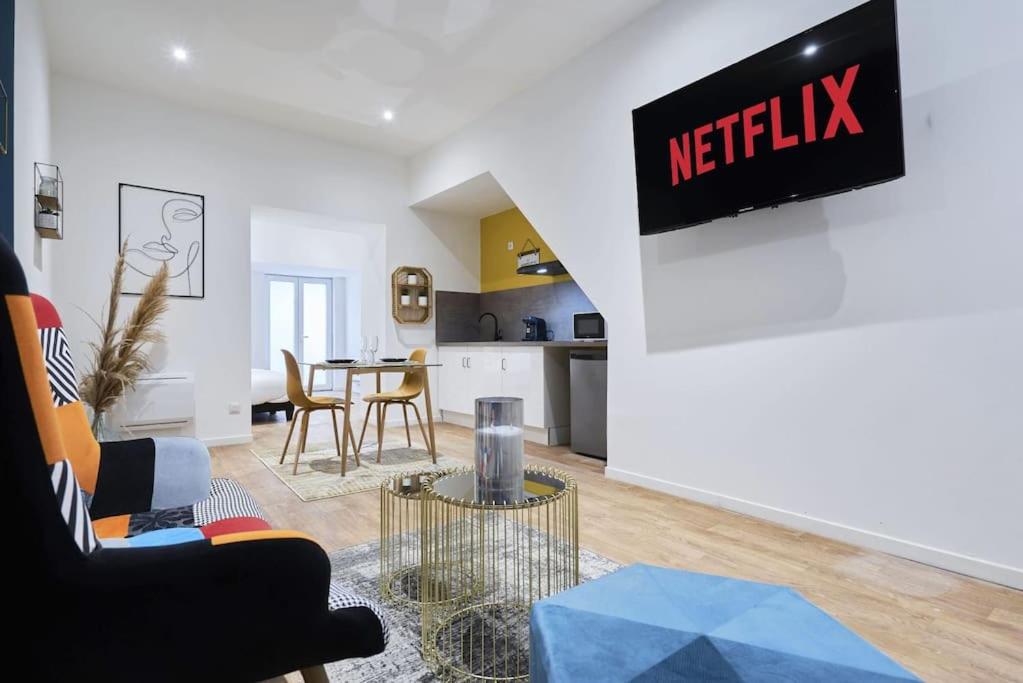 un salon avec une table et une cuisine dans l'établissement Symphony - Olympe Suites & Spa Lille, Tourcoing, à Tourcoing