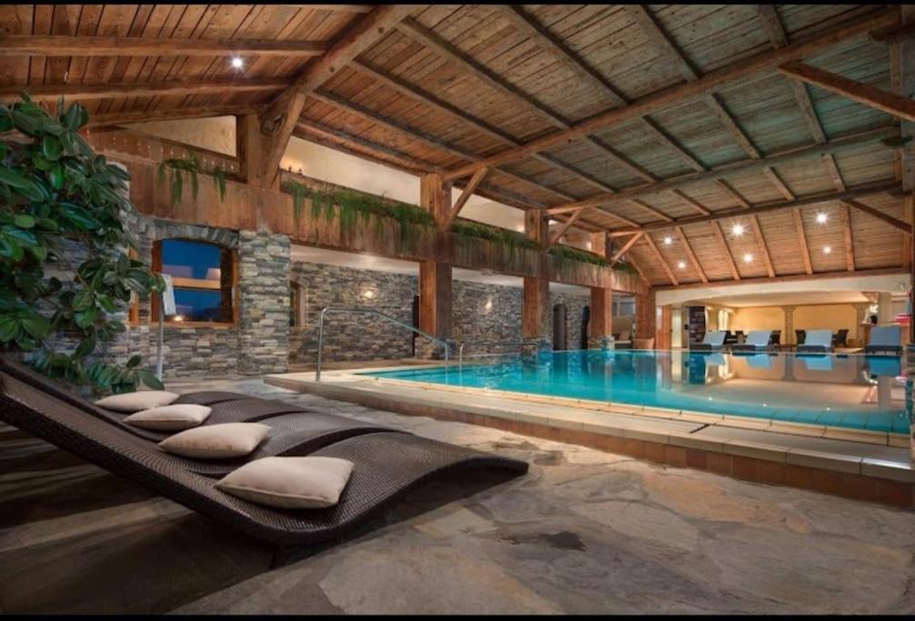 Una gran piscina en un edificio con una gran bañera. en Appartement central avec Spa, en Crans-Montana